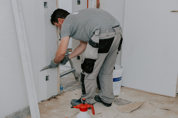 one young man is plastering doorway